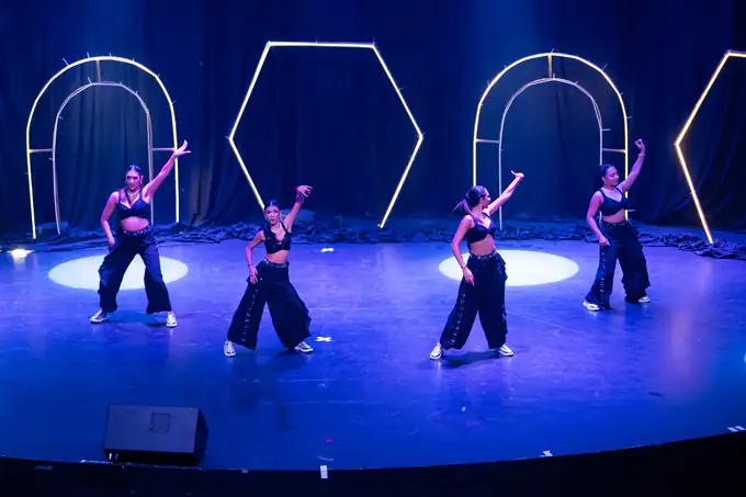 Full company spread across the stage in blue light