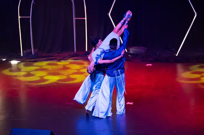 Dancers in blue and red caught mid-leap