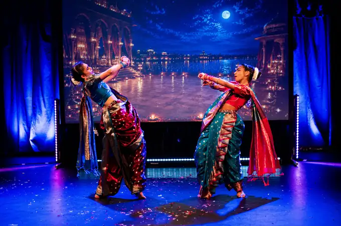 Duet in gold and red performed in front of a projected cinema portrait